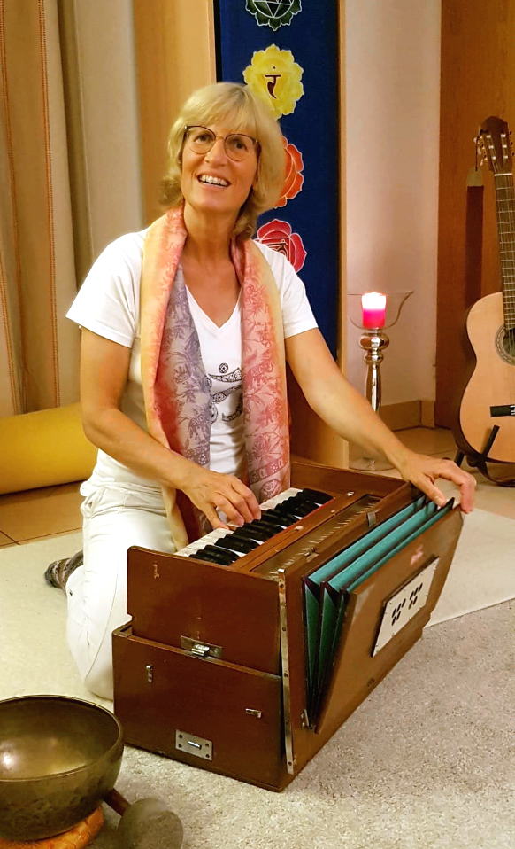 Beate Goldbach mit Harmonium und im Hintergrund ihrer Gitarre